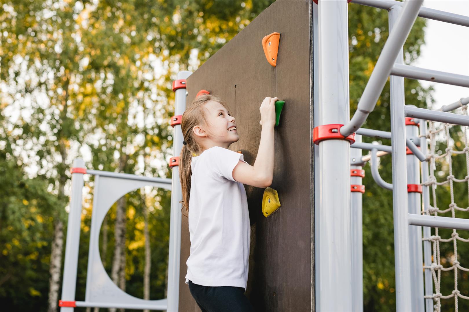 pre-teen-girl-scaling-a-climbing-wall-in-a-summer-2024-10-18-10-04-50-utc